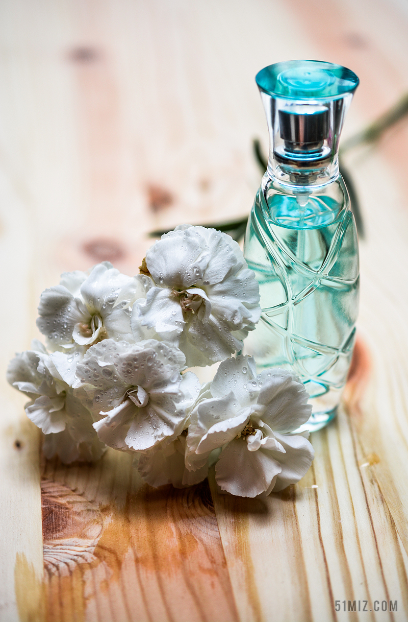 木桌上的香水和鲜花背景图片
