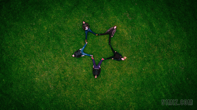 绿色旅游自然五个人躺在草地上摆出星型团队建设图片