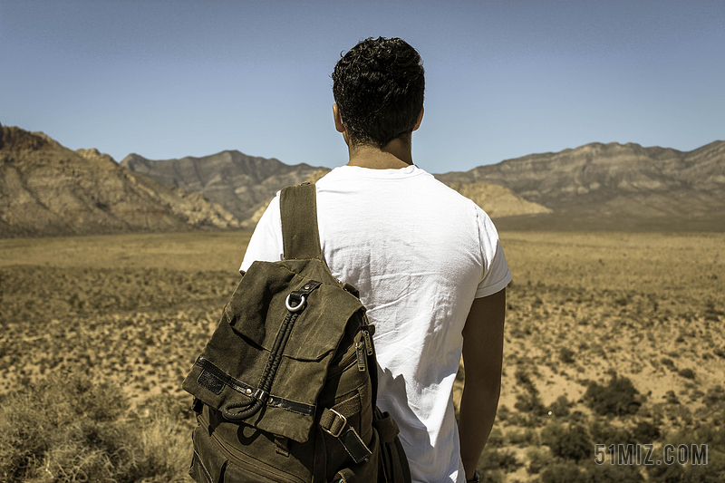 人背影在荒漠上背包的游客背景图片
