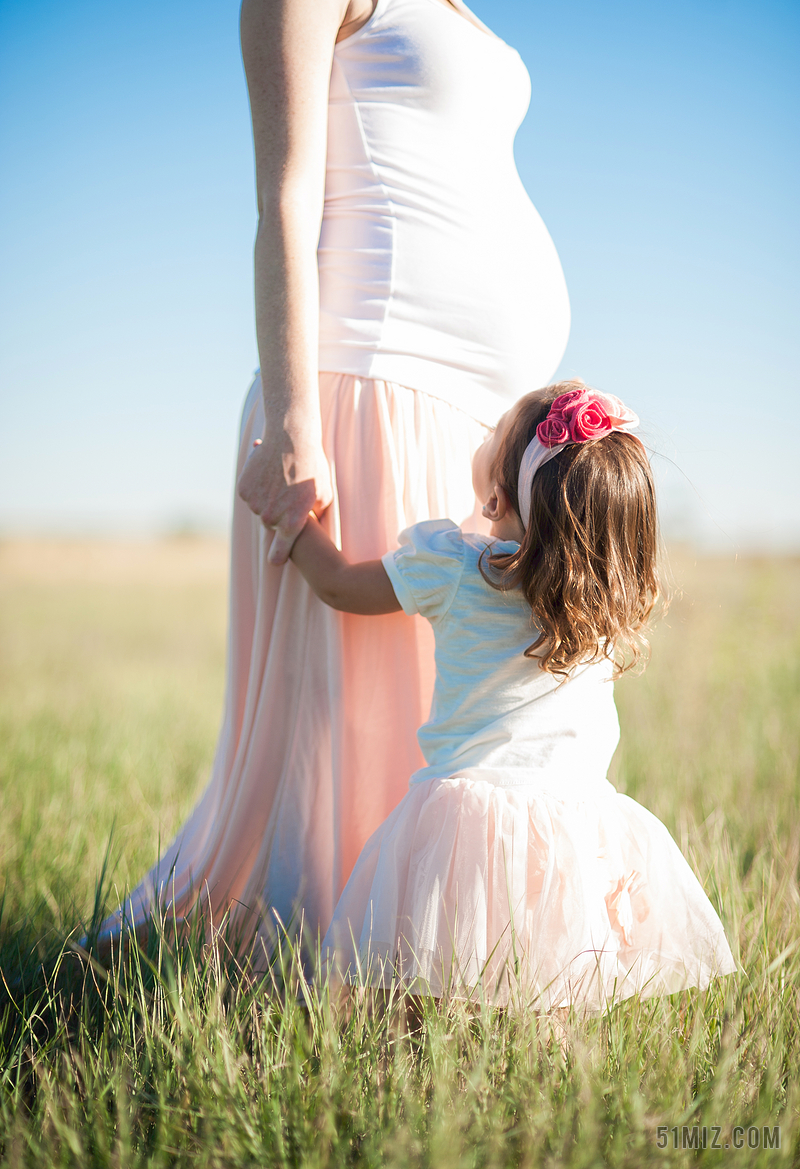 蓝白情感温馨喜悦一位孕妇妈妈牵着女儿的手亲子背景图片